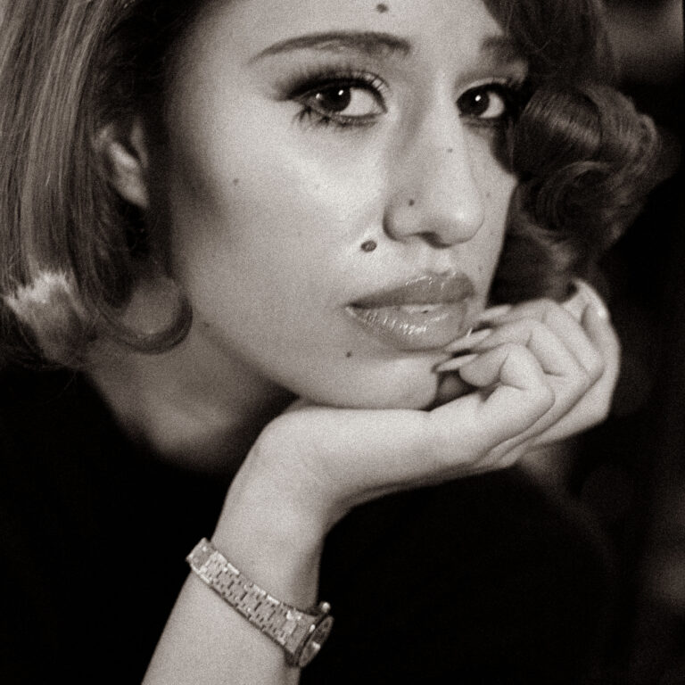 A monochrome close-up captures RAYE in a reflective moment, with her Audemars Piguet watch subtly highlighted on her wrist.