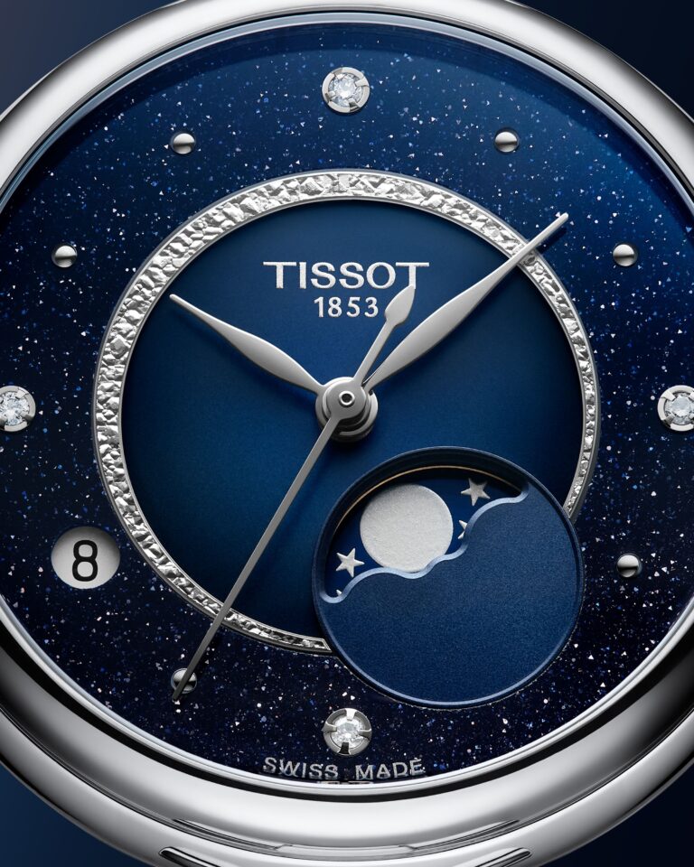 A macro shot of the deep blue Désir dial. Fine starlike flecks scatter across the surface. A hammered silver ring frames the central moonphase display.